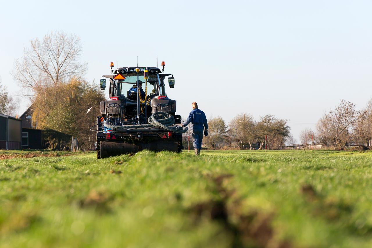 boer met drainagesysteem aan het werk