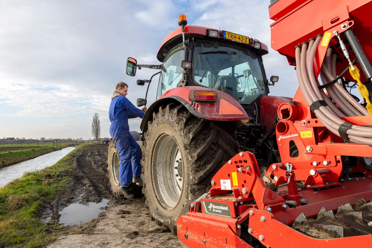 Jonge boer bij een tractor