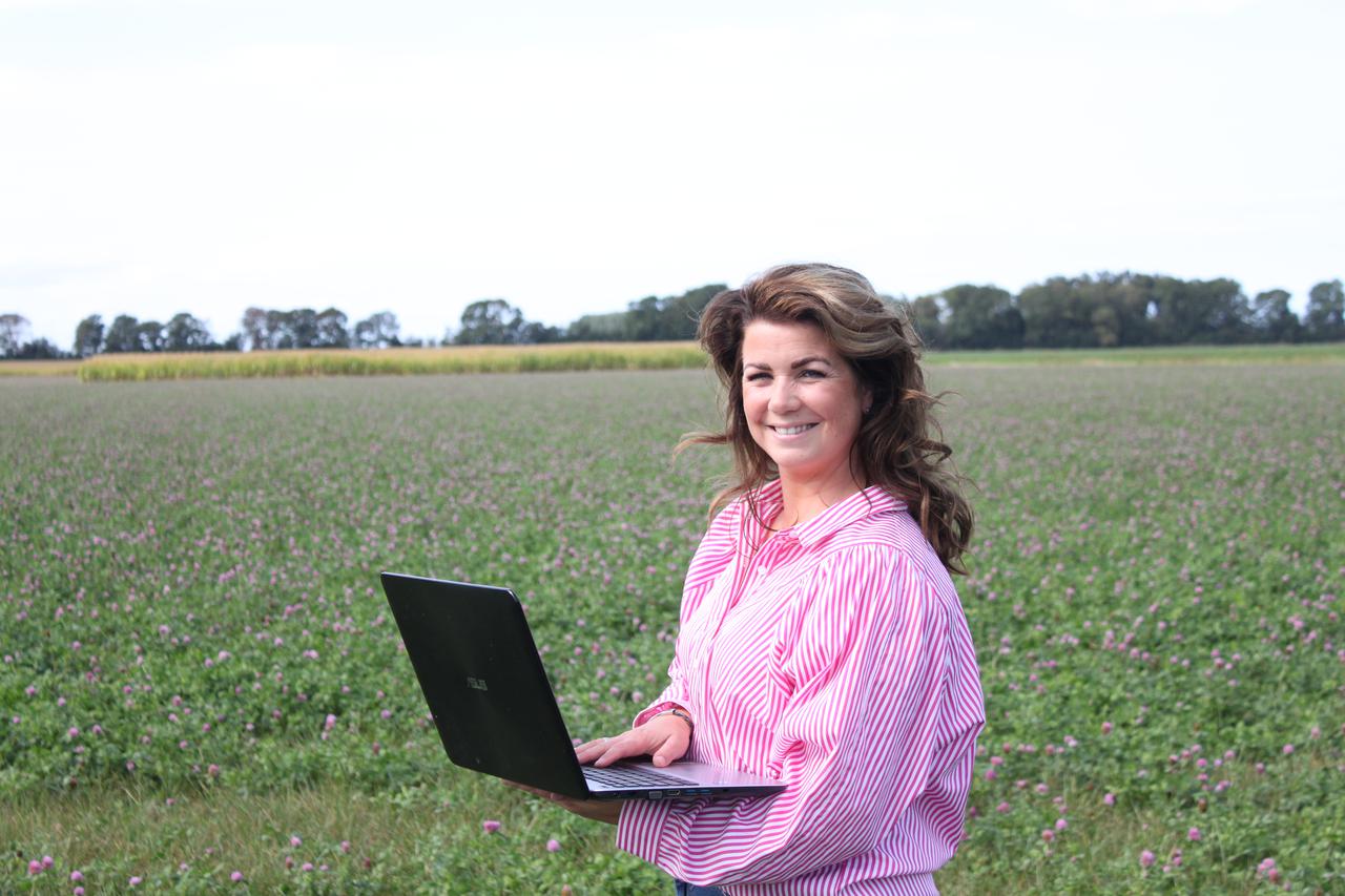 Vrouw in weiland met laptop