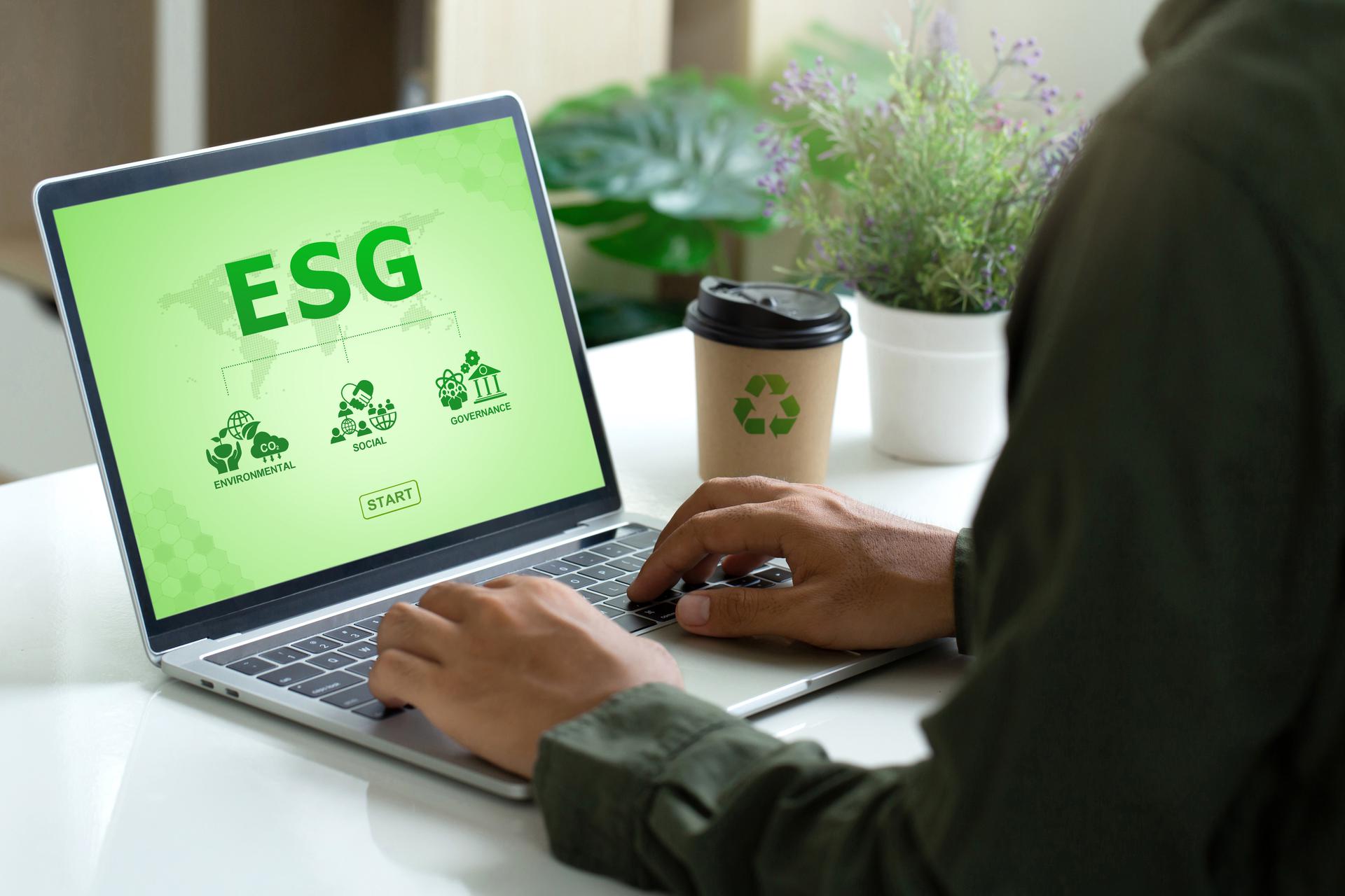 Man zit achter laptop met ESG op het scherm