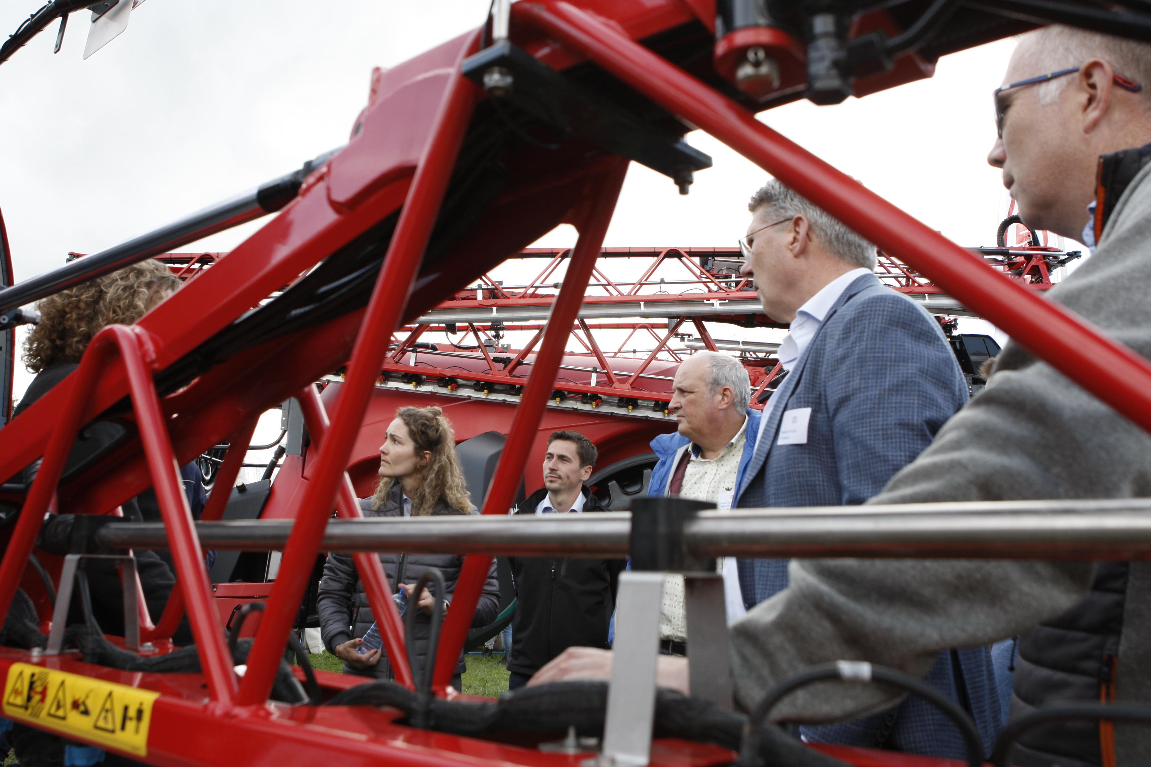 Mensen bekijken een machine en zijn met elkaar in gesprek