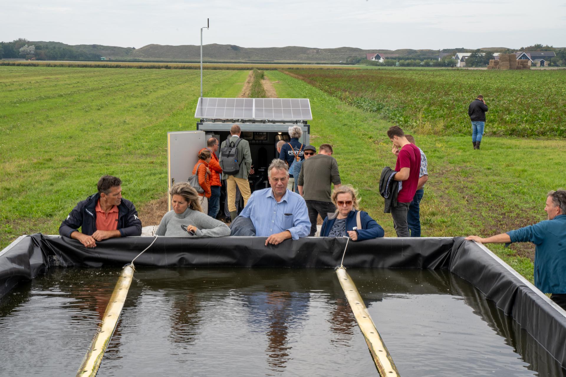 groep mensen staat bij wateropslag op Texel
